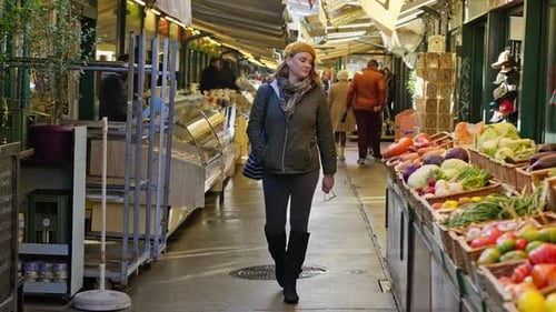 Person walking next to food booths in an open air markets on a cold day, Vienna, Austria