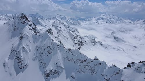 A Snowcovered Mountain Range Under a Brilliant Blue Sky Seen From Above
