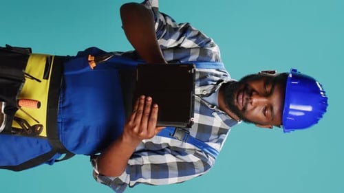 Vertical Video Young Handyman Using Digital Tablet on Camera