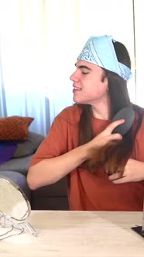 Young Adult Brushes Long Hair Indoors