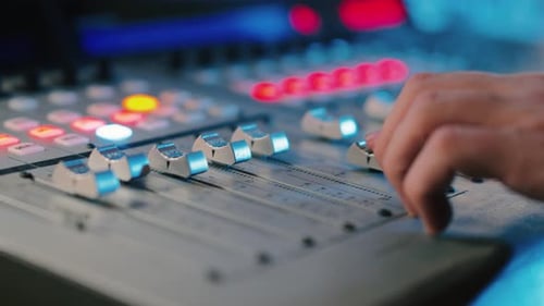 Expert Hand Adjusting Audio Mixer Controls for Perfect Sound in Professional Recording Studio