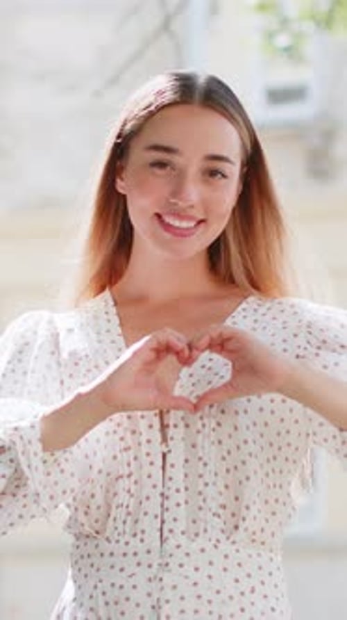 Woman Smiling Making Heart With Hands Outside