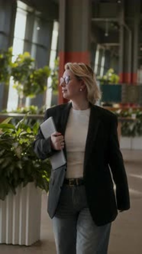 Confident Business Woman Walking Through Modern Office