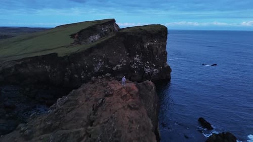 Man Standing on Cliff By the Ocean