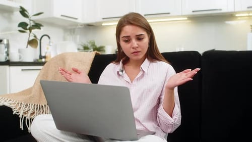 Young Woman Sees Failed Task on Laptop Spreads Hands Unsure Breathes Deep Plans New Approach to Work