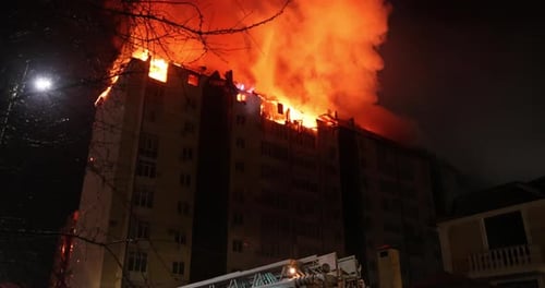 Enorme incendio en un edificio de apartamentos La casa se ve envuelta en llamas por la noche durante el