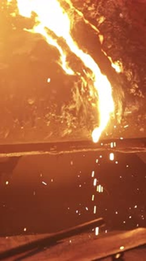 Du métal fondu est coulé, produisant des étincelles lumineuses dans un environnement de fonderie dynamique Stock