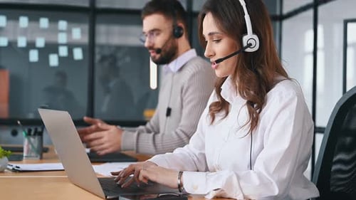 Support-Team mit Kopfhörern. Mann und Frau arbeiten im Büro.
