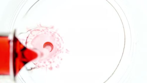 Liquid Pouring Into Beaker with Water From Glass Flask on White Background The Medicine Concept