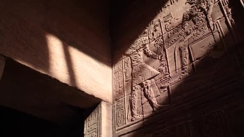 Sunrays hitting the hieroglyphs on the walls inside the temple of Philae, Aswan, Egypt.