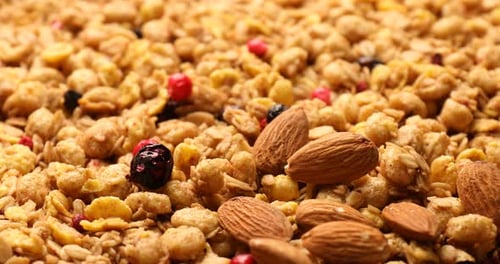 Tasty granola with dried fruits and nuts as background, closeup
