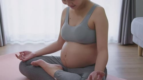 Pregnant Woman Doing Yoga in Home Living Room