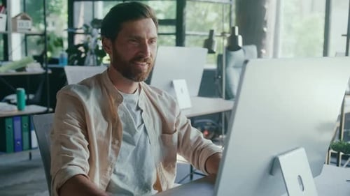 Bearded Man Relaxing at Desk in Modern Office