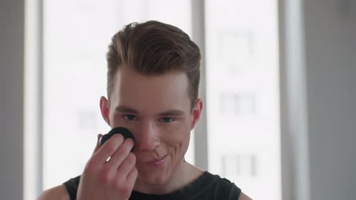 Young Adult Applying Makeup with Cosmetic Sponge
