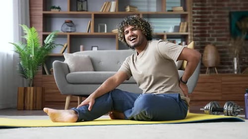 Adult with Back Pain Stretching in Home