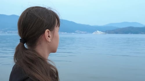 Woman Gazing at Sea With Distant Ship