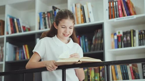 Happy Girl Reading Book in School Library