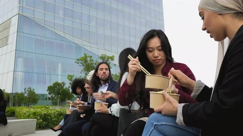 Multiracial business people taking a break eating a meal outside the office