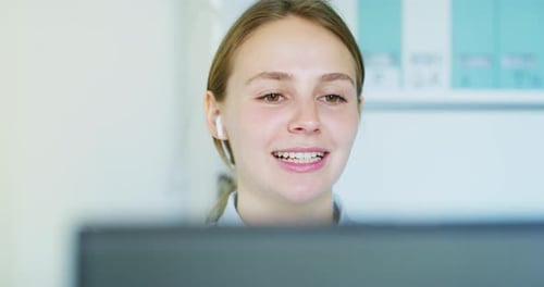 Close up of an Young Blond Woman with Earphones is Making a Video Conference Call with a Computer