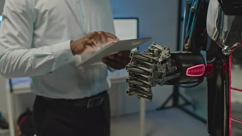 Man Uses Tablet with Advanced Robot Arm