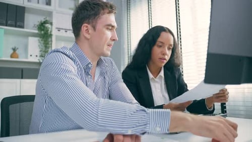 Young Latino business woman work with Caucasian man manager in office.