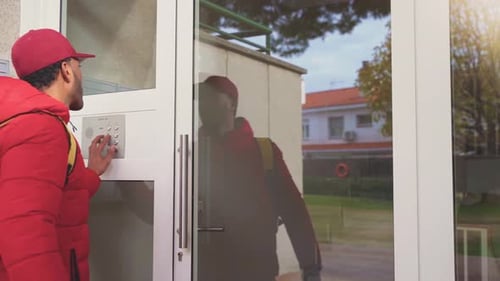 Un livreur de nourriture arrivant à une porte sonne et entre dans l'appartement
