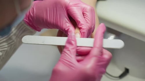 Manicurist Filing Nails in Beauty Salon Close Up