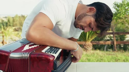 Man Working on Accordion Outdoors on Sunny Day