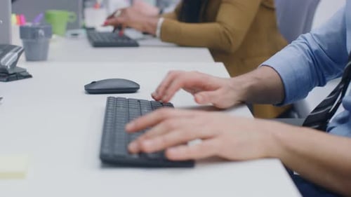 Nahaufnahme eines Mannes, der mit der Maus auf einer Tastatur tippt. Geschäftsmann//Büroangestellter, der am Schreibtisch arbeitet