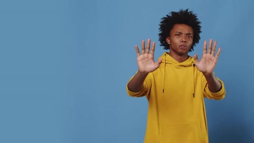Young Man is Making Stop Gesture with His Hands