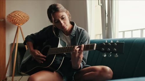 Woman Plays Acoustic Guitar in Home Interior