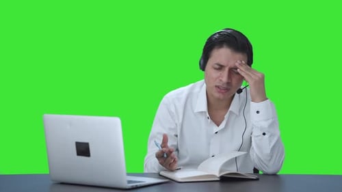 Stressed Indian call center employee trying to understand customer Green screen