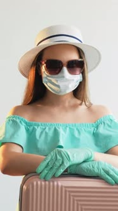 Woman with Face Mask, Gloves, and Suitcase