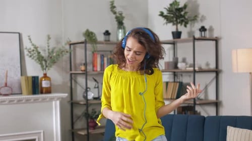 Woman in Headphones Dancing Like Rock Star at Home
