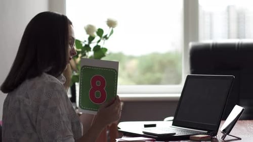 An elementary school teacher teaches a lesson online via a webcam in the classroom.