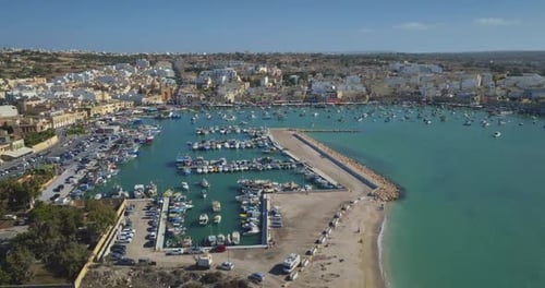 Marsaxlokk Harbor Malta Aerial View Showcasing Colorful Boats Cityscape and Clear Turquoise Water