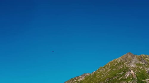 Fallschirmspringer in der Ferne über dem Berggipfel.