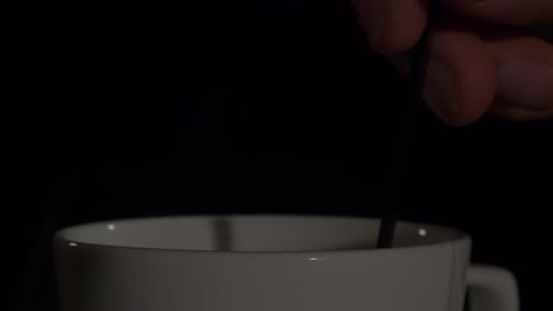 Stirring Cup of Tea with Spoon, Low-Key studio, static close up