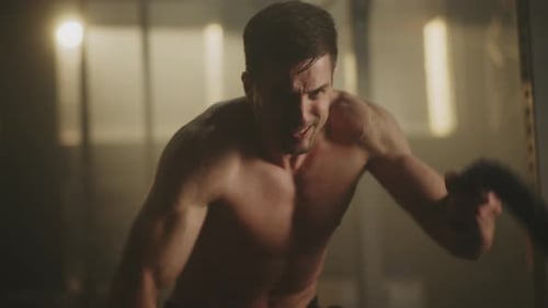 Muscular Man Working Out with Ropes in Gym