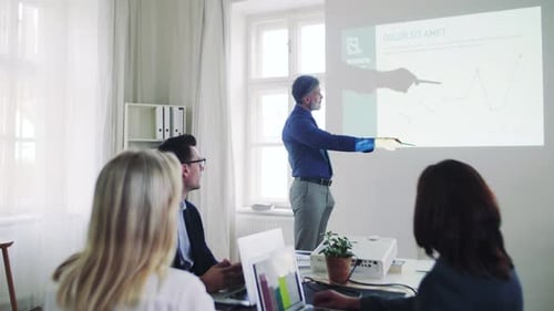 Businessman delivers engaging presentation to colleagues in modern office space
