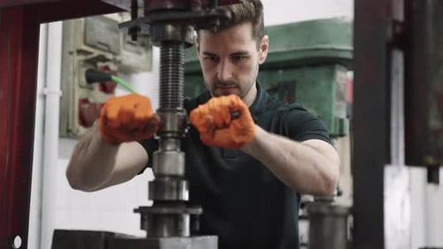 Technician Operating Industrial Machinery in Workshop