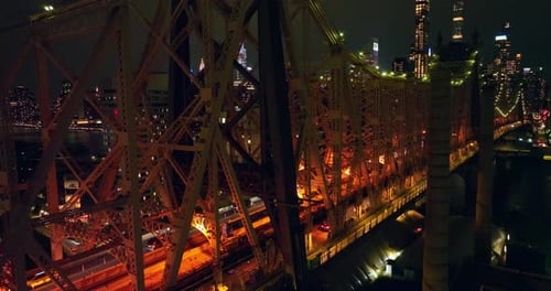 Terrific Queensboro Bridge with busy traffic at nighttime. Drone footage up along the bridge