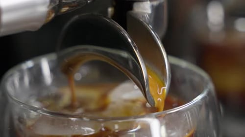 Espresso Extracting Coffee Flowing into Glass Close Up