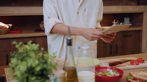 Person cooking with a tablet