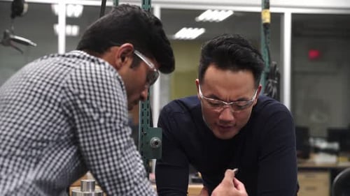 Engineers assembling circuit board with dedication and expertise in research lab