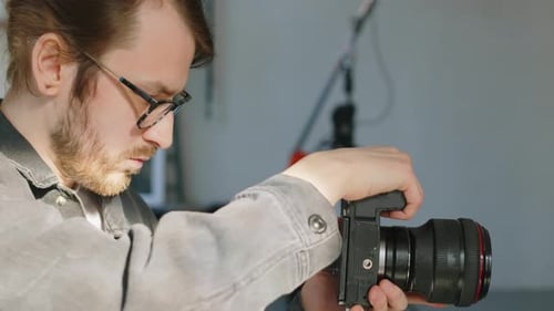 Male Photographer Making Studio Portraits on Professional Camera