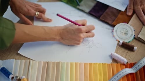 Fashion Artist Hands Drawing Garment Sketch at Tailoring Studio Desk Closeup