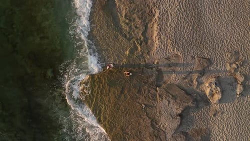 Aerial View The Golden Sun Sets Over Calm Mediterranean Waters with Dramatic Clouds Forming Patterns