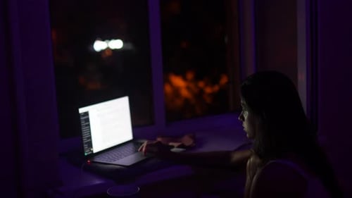 Woman Uses Laptop Computer in Dark Home at Night