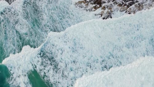 Amazing aerial view of a breaking waves in the coastal rocks